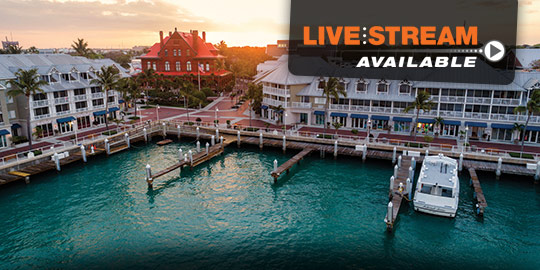 Exterior view of the Key West Opal, a luxury waterfront resort in Key West, Florida. The resort features a multi-story building with balconies overlooking the water and palm trees.