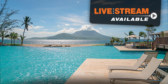 Panoramic view of the Park Hyatt St. Kitts Christophe Harbour, a luxury resort nestled on a cliffside overlooking the Caribbean Sea with a beach, multiple pools, and lush vegetation.