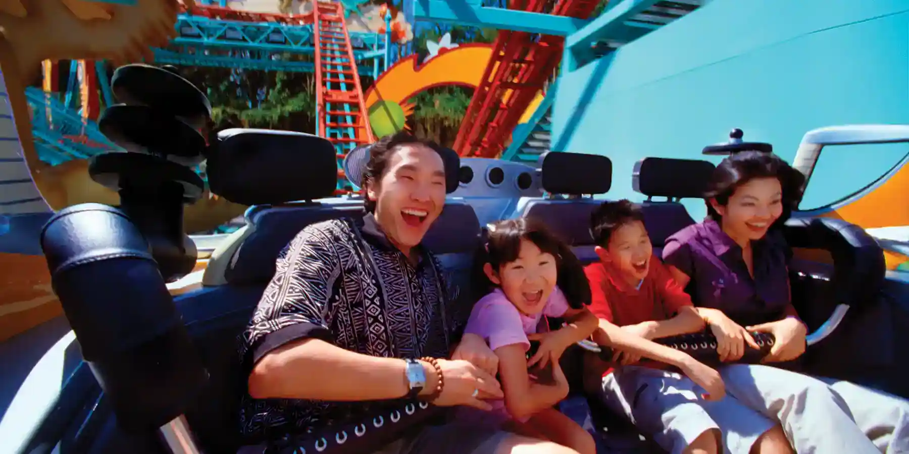 A family enjoying a thrilling roller coaster ride at a theme park, ideal for combining CME and CE conferences with family fun.