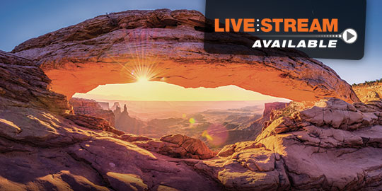 Sunset view of a natural arch in Moab, Utah, during a CME/CE conference, with the red rock formations illuminated by the setting sun.